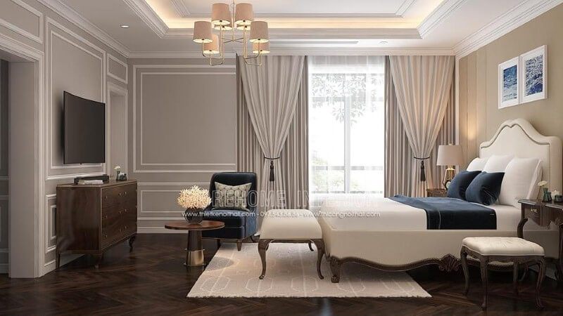 Giường bọc nệm trắng kết hợp với sắc trầm từ ghế, đôn sofa, kệ tivi gỗ óc chó đã tạo nên một bức tranh hài hòa, đẹp mắt và sang trọng trong phòng ngủ master tân cổ điển.